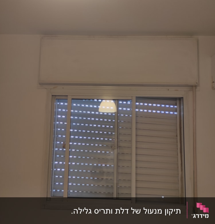 חלון עם תריסים סגורים ומסגרת לבנה
